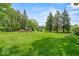 Expansive, well-maintained backyard with mature trees and manicured lawn at 665 Spring Hills Dr, Zionsville, IN 46077