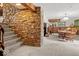 Partially finished basement with stone wall feature, carpeted floors, and dining area at 665 Spring Hills Dr, Zionsville, IN 46077