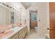 Bright pink bathroom featuring double sinks, ample counter space, and vintage wallpaper at 665 Spring Hills Dr, Zionsville, IN 46077