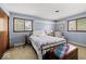 Comfortable bedroom with blue walls and carpet, with two windows for natural light at 665 Spring Hills Dr, Zionsville, IN 46077
