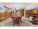 Charming dining room featuring wood paneling, a brick fireplace, and a large wooden table at 665 Spring Hills Dr, Zionsville, IN 46077