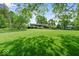 Lush lawn in front yard with mature trees surrounding home at 665 Spring Hills Dr, Zionsville, IN 46077