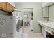 Convenient laundry room with washer, dryer, and built-in utility sink at 665 Spring Hills Dr, Zionsville, IN 46077