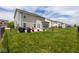 Large, grassy backyard with a black metal fence, a patio area, and plenty of space for activities at 6683 School Branch Dr, Brownsburg, IN 46112