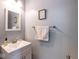 Bright half-bathroom featuring white vanity, chrome fixtures, and decorative mirror at 6683 School Branch Dr, Brownsburg, IN 46112