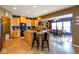 Open-concept kitchen and dining area with wood floors, an island with seating, and modern appliances at 6683 School Branch Dr, Brownsburg, IN 46112