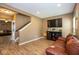 Spacious living area with stairs leading to another floor, with a TV, media center, and sofa at 6683 School Branch Dr, Brownsburg, IN 46112