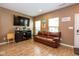 Comfortable living room features wood floors, a sofa, and a media center for entertaining at 6683 School Branch Dr, Brownsburg, IN 46112