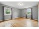 Sunlit bedroom with hardwood floors and two windows offering scenic views at 6839 Chaucer Ct, Indianapolis, IN 46220