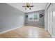 Cozy bedroom with hardwood floors, ceiling fan, and a view to the outdoors at 6839 Chaucer Ct, Indianapolis, IN 46220