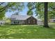 Charming one-story home with a brick facade, well-maintained lawn, and beautiful mature trees at 6839 Chaucer Ct, Indianapolis, IN 46220