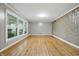 Bright living room featuring hardwood floors, large windows, and a decorative accent wall at 6839 Chaucer Ct, Indianapolis, IN 46220