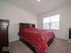 Cozy bedroom with a queen-size bed, neutral carpet, and natural light from the window at 7234 Darley Ln, Indianapolis, IN 46259