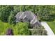 Stunning aerial view of a brick home surrounded by lush greenery and mature trees at 7372 Fox Hollow Rdg, Zionsville, IN 46077
