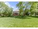 Expansive backyard with lush green lawn, mature trees, patio, and well-manicured landscaping at 7372 Fox Hollow Rdg, Zionsville, IN 46077