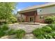 View of a backyard patio with a wooden pergola, a brick house, and landscaped shrubbery at 7372 Fox Hollow Rdg, Zionsville, IN 46077