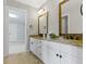 Bathroom features a double vanity with granite countertop and decorative mirrors at 7372 Fox Hollow Rdg, Zionsville, IN 46077