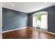 A bedroom with blue walls, hardwood floors, and a large arched window at 7372 Fox Hollow Rdg, Zionsville, IN 46077