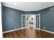 A bedroom with blue walls, hardwood floors, and French doors that open to a view of the staircase at 7372 Fox Hollow Rdg, Zionsville, IN 46077