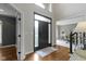 Welcoming foyer featuring hardwood floors, a stylish black door, and abundant natural light at 7372 Fox Hollow Rdg, Zionsville, IN 46077