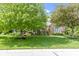 Charming brick home showcasing a neatly manicured lawn with mature trees at 7372 Fox Hollow Rdg, Zionsville, IN 46077
