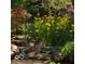 Lush garden featuring yellow irises, mature trees, pond and decorative butterfly sculpture at 7372 Fox Hollow Rdg, Zionsville, IN 46077