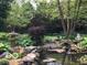Backyard landscape features a pond, rocks, and small waterfall, creating a tranquil oasis at 7372 Fox Hollow Rdg, Zionsville, IN 46077