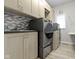 Well-organized laundry room with modern washer and dryer, cabinets, and a sink at 7372 Fox Hollow Rdg, Zionsville, IN 46077