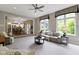 An open living room with large windows, a view of the kitchen, and a comfortable seating arrangement at 7372 Fox Hollow Rdg, Zionsville, IN 46077