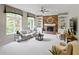 Bright and inviting living room featuring a brick fireplace, built-in shelves, and large windows at 7372 Fox Hollow Rdg, Zionsville, IN 46077