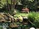 Pond featuring lush greenery and a decorative stone frog statue at 7372 Fox Hollow Rdg, Zionsville, IN 46077