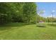 Expansive backyard with a trampoline, mature trees, and a glimpse of a charming country house at 7730 Bear Creek Rd, Morgantown, IN 46160