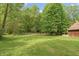 Expansive backyard with lush green grass, trees, and partial view of the home's exterior at 7730 Bear Creek Rd, Morgantown, IN 46160