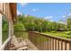 Cozy wooden balcony with seating overlooking a lush green lawn and wooded landscape under a sunny blue sky at 7730 Bear Creek Rd, Morgantown, IN 46160