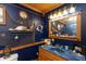 Nautical themed bathroom featuring a dark blue marble vanity, a mirror and ample storage at 7730 Bear Creek Rd, Morgantown, IN 46160