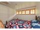 Cozy bedroom with unique window design and a quilt-covered bed featuring patriotic patterns at 7730 Bear Creek Rd, Morgantown, IN 46160