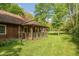Cozy cabin exterior showcasing a welcoming covered porch, rustic details, and a vibrant green lawn at 7730 Bear Creek Rd, Morgantown, IN 46160