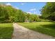 Picturesque gravel driveway leading to a home nestled in a lush, green landscape with mature trees at 7730 Bear Creek Rd, Morgantown, IN 46160