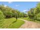 Expansive front yard leading to a charming country house surrounded by mature trees and well-maintained grounds at 7730 Bear Creek Rd, Morgantown, IN 46160