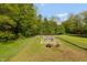 Fenced kennel area nestled in a lush, green landscape with mature trees in the background at 7730 Bear Creek Rd, Morgantown, IN 46160