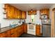 Functional kitchen featuring vintage wood cabinets, black countertops, and modern stainless steel appliances at 7730 Bear Creek Rd, Morgantown, IN 46160