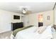 Bright bedroom featuring neutral carpet, a ceiling fan, and an adjacent en-suite bathroom with dual sinks at 7771 Delbrook Dr, Indianapolis, IN 46260