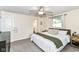 Comfortable bedroom featuring neutral carpet, a ceiling fan, and large windows offering natural light at 7771 Delbrook Dr, Indianapolis, IN 46260
