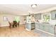 View of kitchen with stainless appliances, sage green cabinets, and dining area featuring an adjacent breakfast bar at 7771 Delbrook Dr, Indianapolis, IN 46260