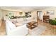 Open-concept living area with a large sofa, stylish rug, and seamless flow to the kitchen and dining at 7771 Delbrook Dr, Indianapolis, IN 46260