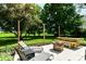 Relaxing outdoor patio area with a stone firepit, seating, and string lights amongst a luscious backyard at 7771 Delbrook Dr, Indianapolis, IN 46260