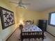 Cozy bedroom featuring yellow walls, a ceiling fan, and a comfortable bed with a decorative quilt at 8055 Foxchase Dr, Indianapolis, IN 46256