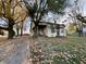 Quaint, two-story home featuring a covered porch and mature trees, set amidst a colorful autumn landscape at 8345 N State Road 109, Wilkinson, IN 46186