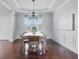 Elegant dining room featuring hardwood floors, wainscoting, and a modern chandelier over a large table at 902 Racetime Rd, Westfield, IN 46074