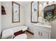Charming bathroom with a claw-foot tub, vanity, wood-trimmed windows, and wood-look floors at 910 E Pike St, Martinsville, IN 46151
